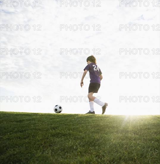 Boy in uniform kicking soccer ball. Date : 2008