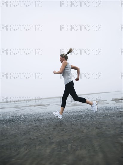 Woman jogging on foggy beach. Date: 2008