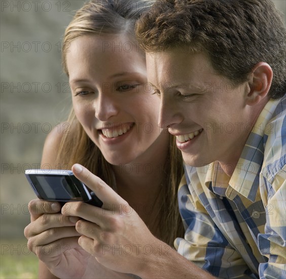 Close up of couple text messaging. Date : 2008