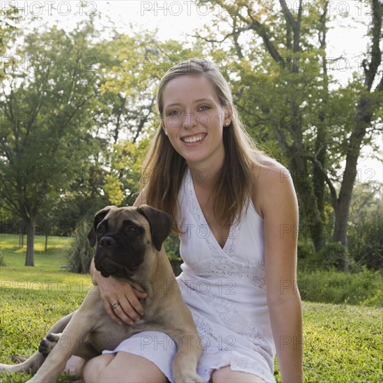 Portrait of woman sitting in grass with dog. Date : 2008