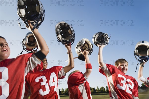 Football team holding helmets overhead. Date : 2008