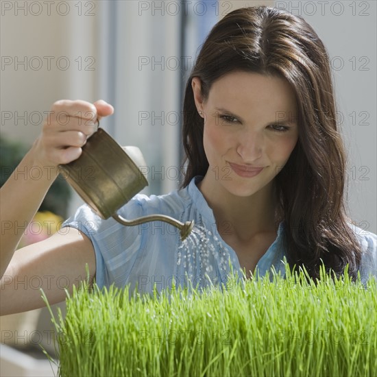 Woman watering grass.