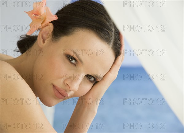 Close up of woman with flower in hair.