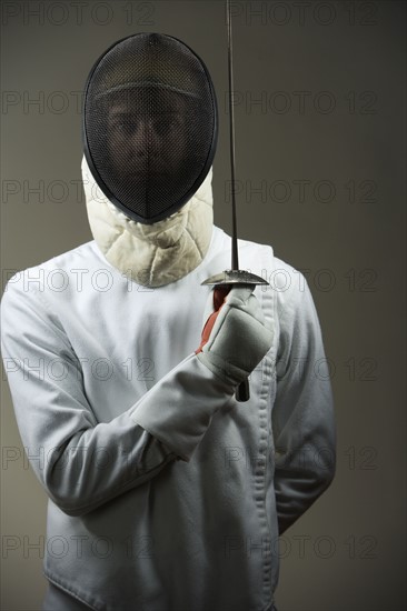 Portrait of fencer in uniform and mask holding fencing foil. Date : 2008