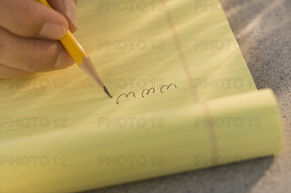 Man writing “www” on legal pad.