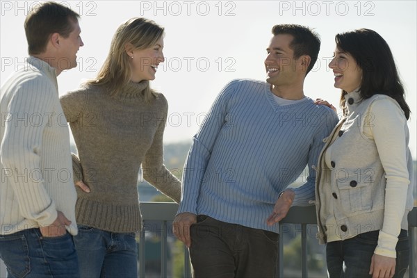 Couples talking on balcony.