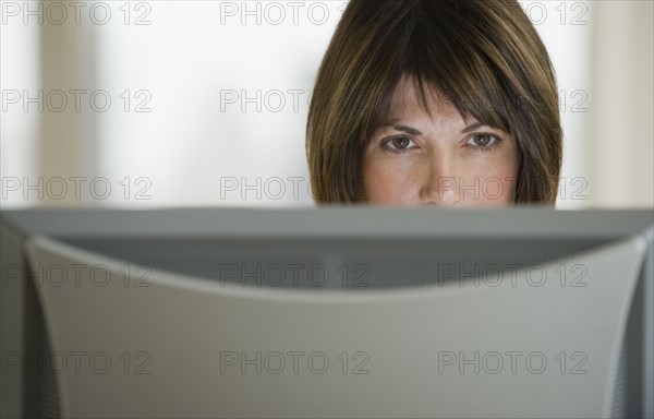 Close up of woman looking at computer monitor.