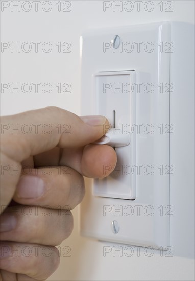 Man adjusting light dimmer.