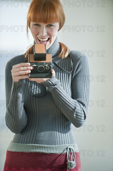 Woman holding vintage camera.