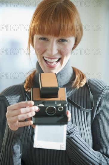 Woman holding vintage camera.