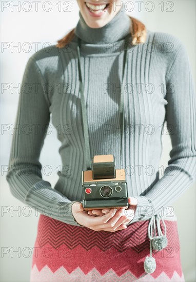 Woman holding vintage camera.