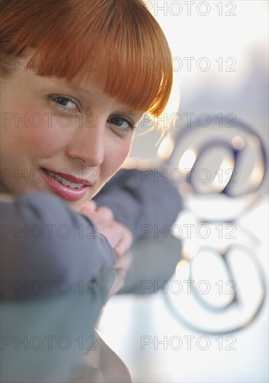 Woman looking at “at” symbol.