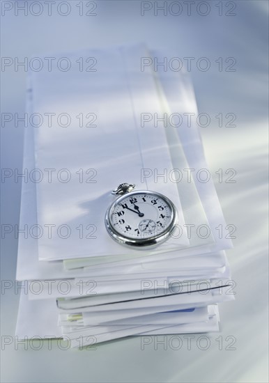 Pocket watch on stack of mail.