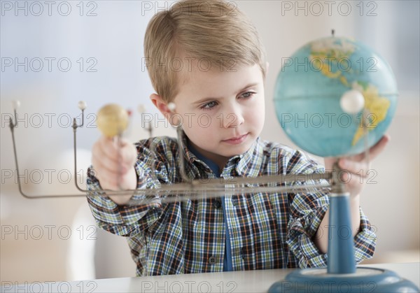 Boy looking at globe.