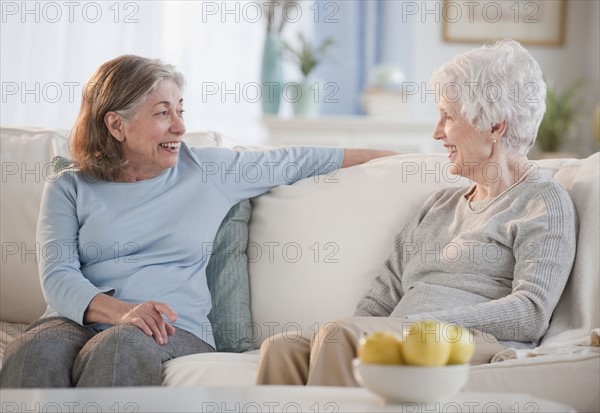 Senior woman talking on sofa.