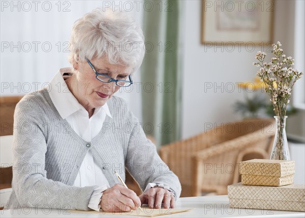 Senior woman writing letter.