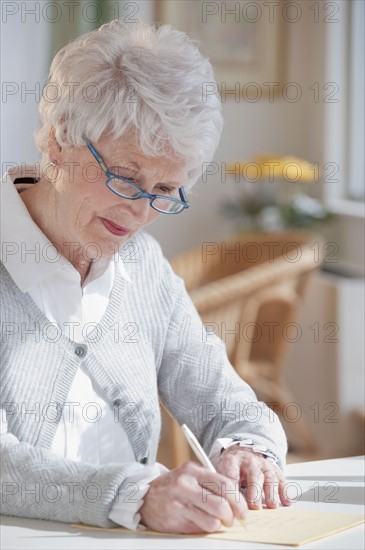 Senior woman writing letter.