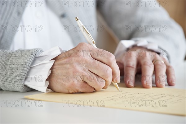 Senior woman writing letter.