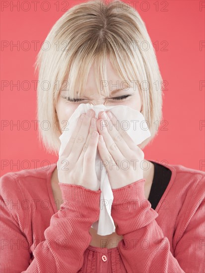 Woman blowing nose. Photographe : Jamie Grill