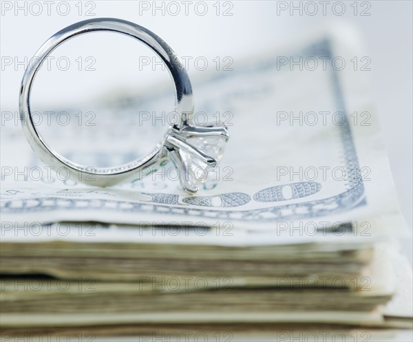 Wedding cake toppers on stack of cash. Photographe : Jamie Grill