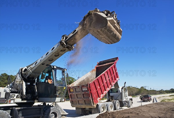 Dump truck and loader on construction site. Photographe : fotog