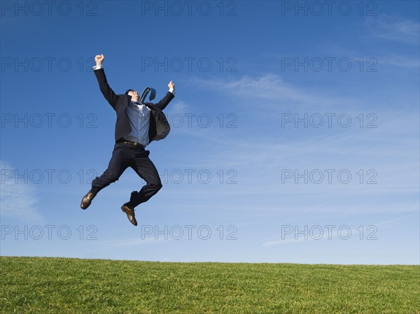 Businessman jumping in air.