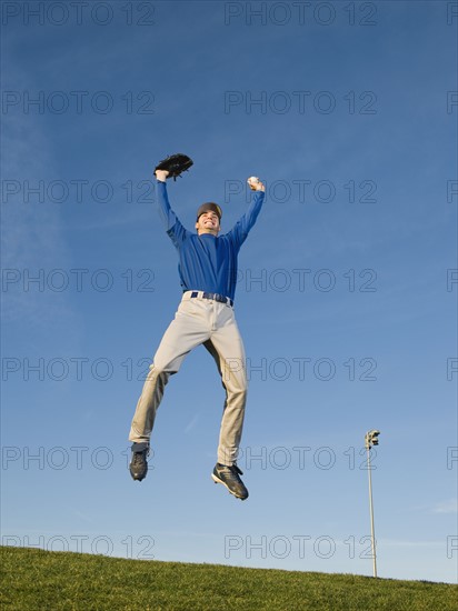 Baseball player jumping in air.