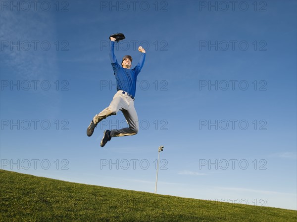 Baseball player jumping in air.