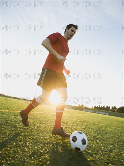 Soccer player dribbling ball.