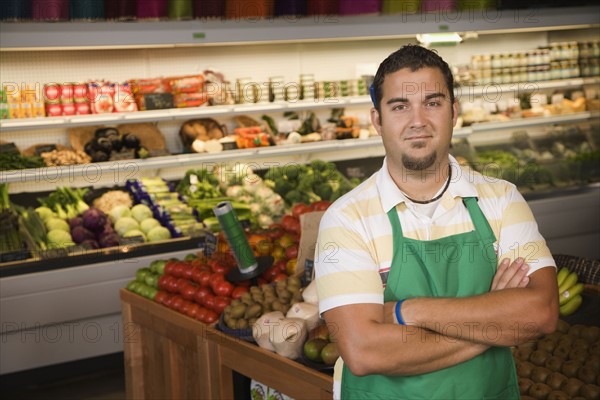 Worker posing in produce section. Photographe : Hill Street Studios