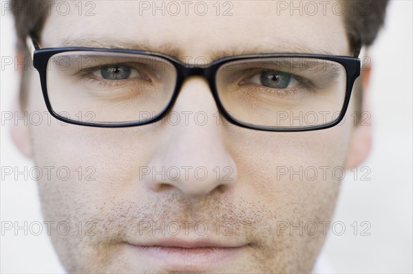 Close up of man wearing eyeglasses. Photographe : PT Images