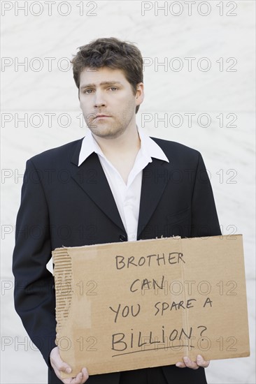 Businessman begging for money. Photographe : PT Images