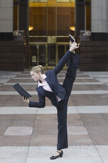 Businesswoman dancing in urban setting. Photographe : PT Images