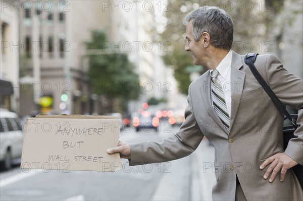 Businessman hitchhiking. Photographe : PT Images