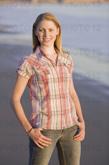 Woman standing on beach. Photographe : PT Images