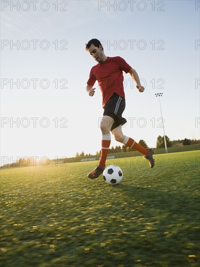 Soccer player dribbling ball.