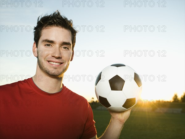 Soccer player holding ball.