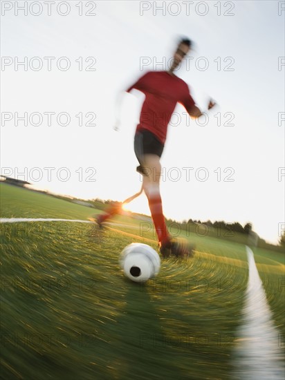 Soccer player dribbling ball.