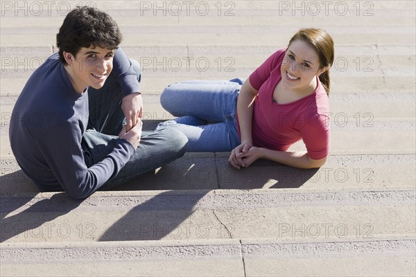 Friends sitting on steps. Photographe : PT Images