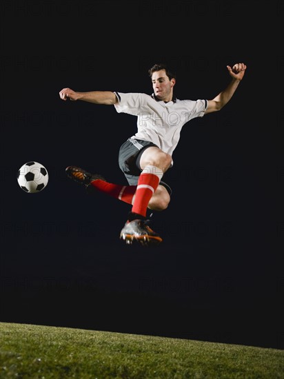 Soccer player kicking ball.