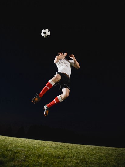 Soccer player heading ball.