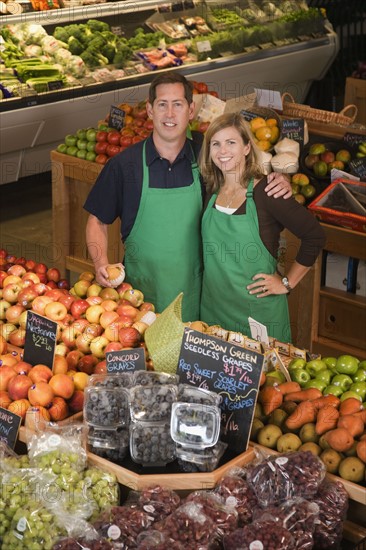 Store owners posing in produce section. Photographe : Hill Street Studios