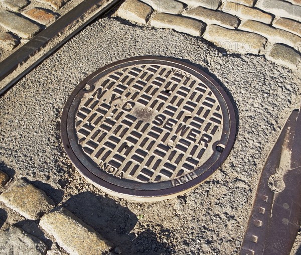 Sewer cover on urban street. Photographe : fotog