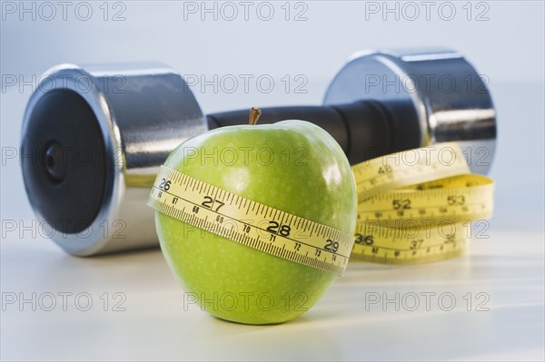 Apple wrapped in tape measure. Photographe : Daniel Grill