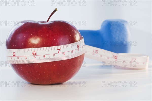 Apple wrapped in tape measure. Photographe : Daniel Grill