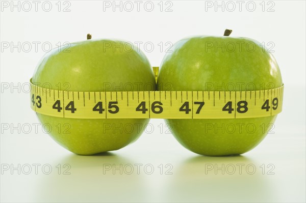 Apples wrapped in tape measure. Photographe : Daniel Grill