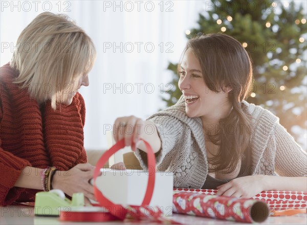 Women wrapping Christmas gifts. Photographe : Jamie Grill