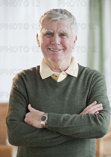 Senior man with arms crossed.