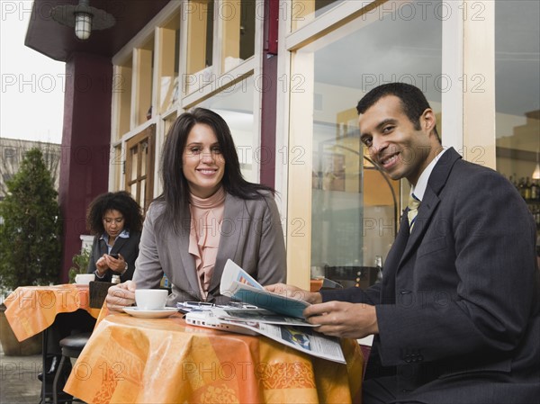 Businesspeople meeting at outdoor cafe.