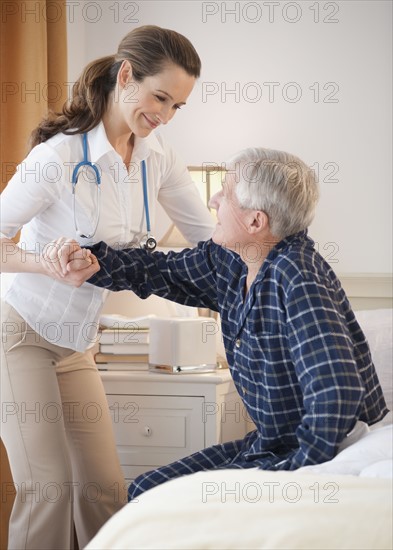 Nurse helping senior man out of man.